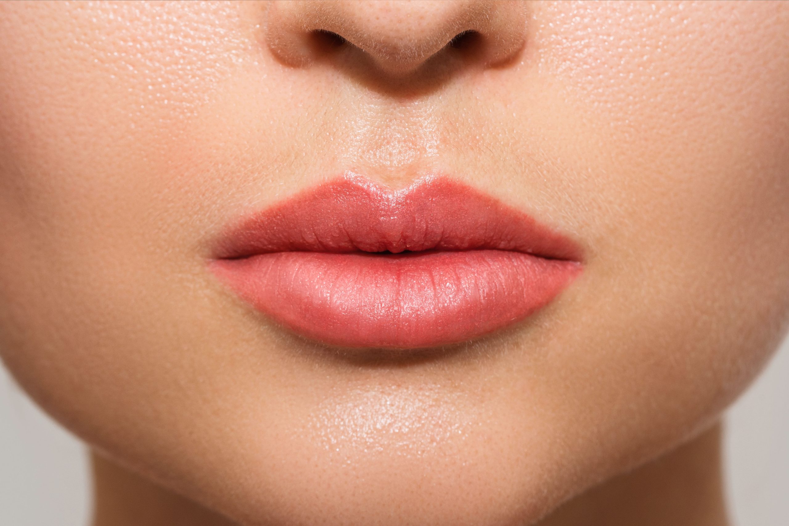 Closeup of female lips after permanent makeup lip blushing procedure